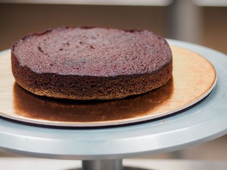 Chef cake designer preparing layered creamy cake base for frosted decoration and topping