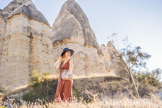 Woman tourist on background of Unique geological formations in Love Valley in Cappadocia, popular travel destination in Turkey.