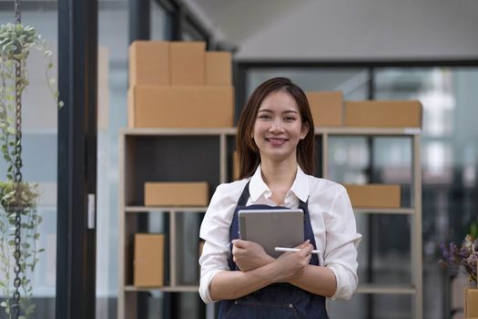 Portrait of Asian young woman SME working with a box at home the workplace.start-up small business owner, small business entrepreneur SME or freelance business online and delivery concept...