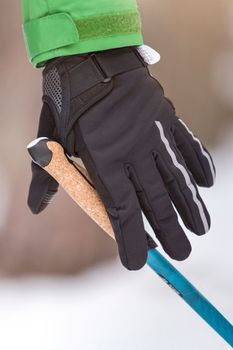 Nordic walking. Healthy lifestyle, outdoor sports in winter. A man's hand squeezes the handle of a cane for Nordic walking. Attach a stick to your hand.