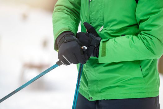 Nordic walking. Healthy lifestyle, outdoor sports in winter. A man's hand squeezes the handle of a cane for Nordic walking. Attach a stick to your hand.