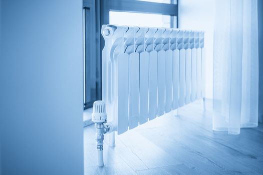 White big radiator near window in a modern room