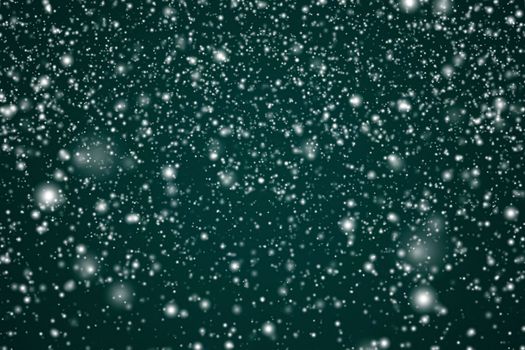 Winter holidays and wintertime background, white snow falling on festive green backdrop, snowflakes bokeh and snowfall particles as abstract snowing scene for Christmas and snowy holiday design. High quality 4k footage
