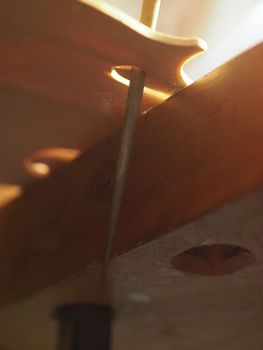 violinmaker cutting and sawing golden period cremonese violin model fholes with a blade with precision