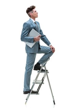 Young handsome businessman climbing up the success ladder looking up, isolated on white background. 