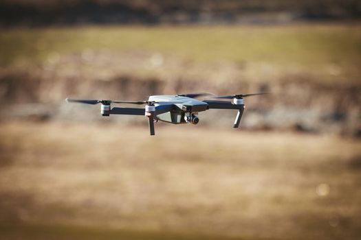 Drone take off from land and flying above field, for take aerial photo.