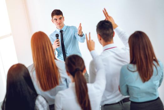 Young businessman explaining to her colleagues plan of work. The team is listening.