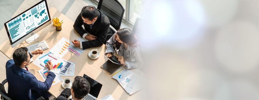 Smart businessman and businesswoman talking discussion in widen group meeting at office table in a modern office interior. Business collaboration strategic planning and brainstorming of coworkers.