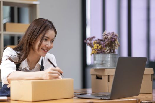 Successful entrepreneur business woman with online sales and Parcel shipping in her home office, prepare parcel box of product for deliver to customer...