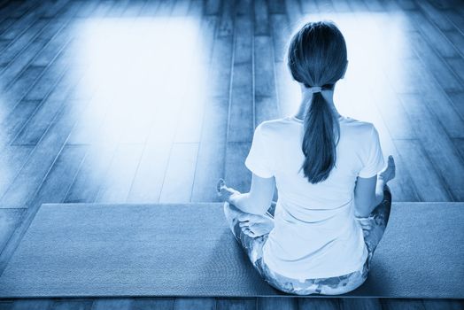 Young woman meditating sitting in lotus position