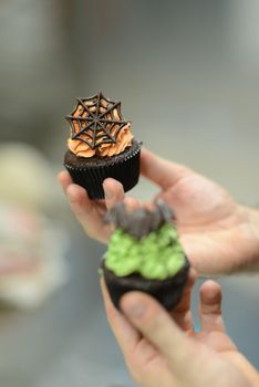 artisan chef preparing handmade with icing and chocolate spider vampire topper