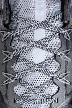 Sneakers close-up. Shoelaces of new sports shoes in gray, lacing sneakers close-up, top view. Mesh elastic laces for fitness. Sport and active lifestyle concept