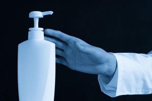 Bottles of hand sanitizers and liquid soap on a black background