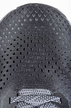 Mesh fabric of sports shoes in gray color. Shoes made of mesh fabric with a textile texture, for an active lifestyle, running and sports. Modern running shoes close-up