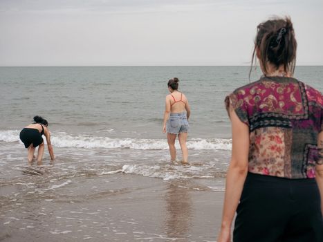 Three girls splashing each other in the beach