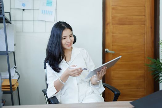 business owner or Asian female marketers are using tablet computer in office work.