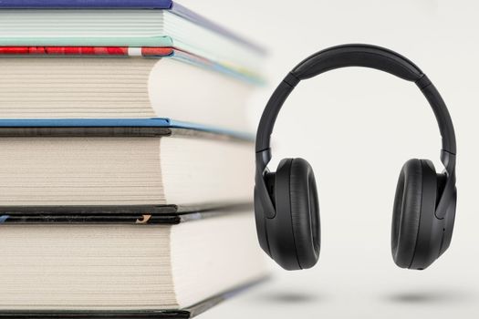 Audiobooks. Audiobook concept, stack of books and headphones with space for copy space. Choice between books and audio