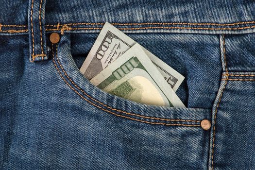 Stack of 100 dollar bills in jeans pocket. Money in the front pocket of jeans. The concept of investment, cash, wealth and profit.