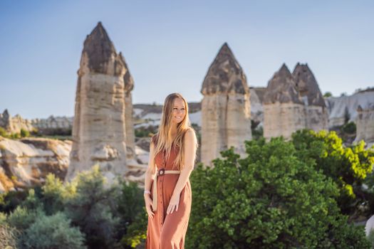 Woman tourist on background of Unique geological formations in Love Valley in Cappadocia, popular travel destination in Turkey.