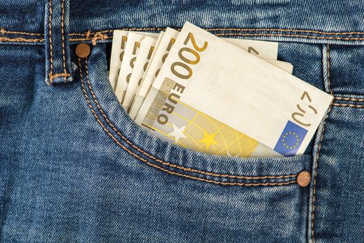 A stack of 200 euro bills in a jeans pocket. Money in the front pocket of jeans. The concept of investment, cash, wealth and profit, copyspace