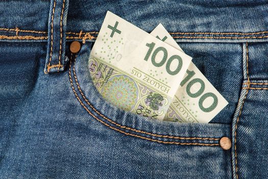 100 zloty banknotes in jeans pocket. Money in the front pocket of jeans. The concept of investment, cash, wealth and profit, copyright