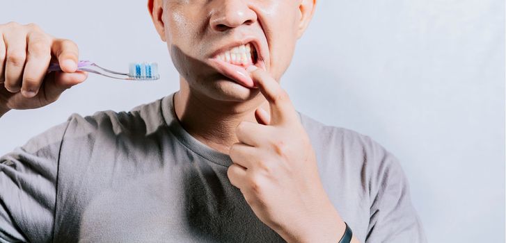 Person with gingivitis holding toothbrush. People holding toothbrush with gum pain. Man holding toothbrush with gum pain, People holding toothbrush with gum problem isolated