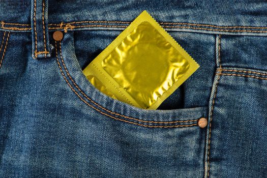 Safe sex, protection from unwanted pregnancy. Protection against sexual diseases, condoms in the pocket of blue jeans