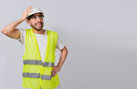 Worried builder engineer holding his head. Worried engineer man looking up. Troubled young engineer holding his head looking up. Engineer problems concept