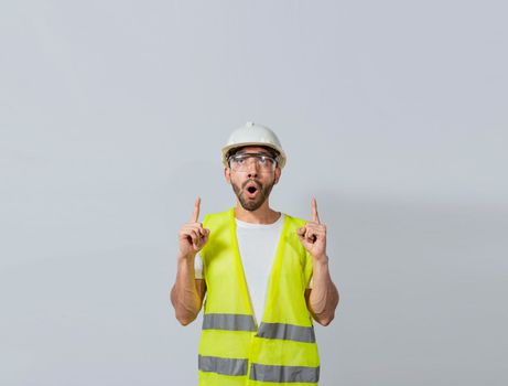 Surprised young architect pointing up, Amazed engineer pointing at an advertisement. Concept of an engineer with astonished face pointing at blank space, Amazed engineer man pointing up