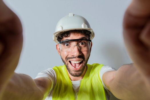 Smiling male engineer taking a selfie looking at camera. Funny builder engineer taking a selfie isolated, Engineer taking a selfie isolated. View of male engineer taking a selfie isolated
