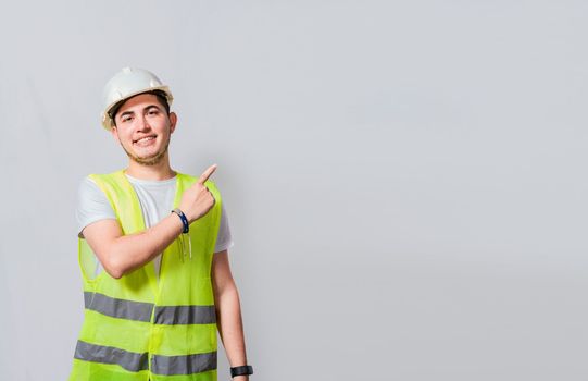Engineer man pointing to side. Builder engineer pointing finger to the right isolated, Portrait of engineer man pointing aside, Construction engineer with vest pointing at an advertisement
