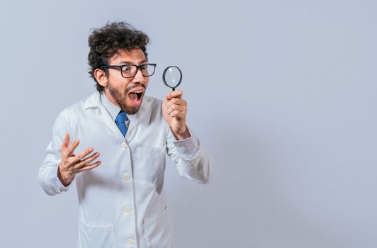 Surprised scientist observing with a magnifying glass to the side. Scientist holding a magnifying glass looking to the side, Man in a white coat with a magnifying glass looking advertisement