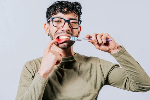 Man holding toothbrush with gum pain, People holding toothbrush with gum problem isolated. Young man with gingivitis holding toothbrush. People holding toothbrush with gum pain