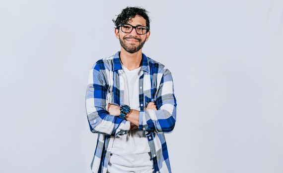 Friendly young man with crossed arms on isolated background. Teenage guy smiling with crossed arms isolated. Smiling bearded handsome man with crossed arms isolated