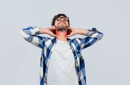 Young man with shoulder and neck problems, Person in pain rubbing his neck isolated, Concept of people with stress and neck pain problems. Tired guy with neck pain isolated