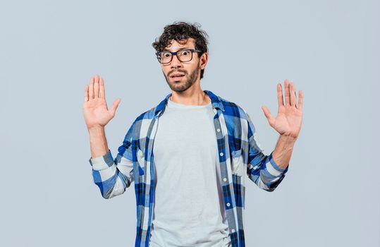 Scared bearded man with raised hands in front. Scared and horrified man with raised palms, Man with a frightened face with his hands raised in front. Portrait of scared person with raised hands