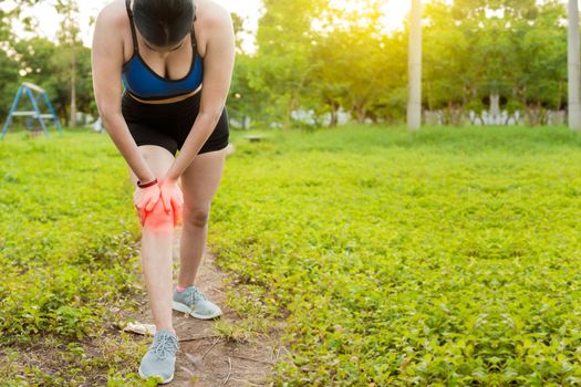 Runner woman with knee pain outdoors. Athlete knee pain and fractures concept, Athlete woman with knee muscle pain. Athlete girl on the ground with knee pain outdoors