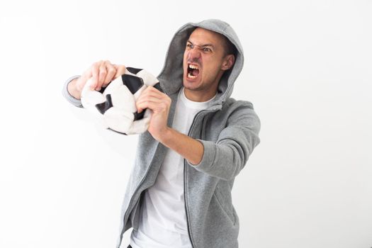 Handsome american man playing footbal holding soccer ball over white background shouting and screaming loud to side with hand on mouth. High quality photo