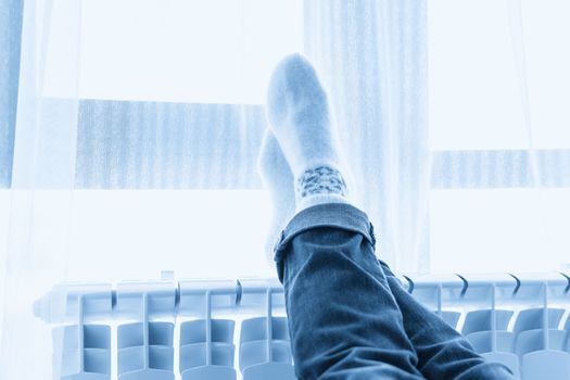 Woman warming up with feet on heater