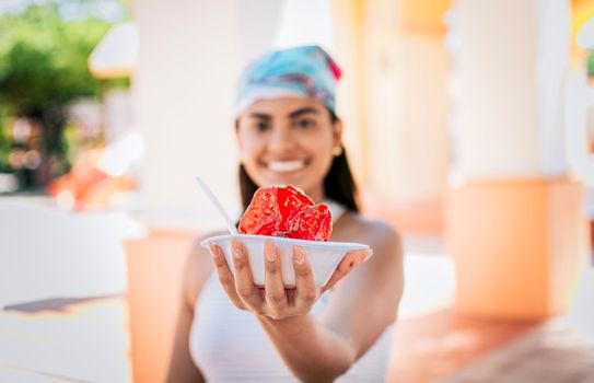 Smiling girl holding shaved ice on the street. Close up of young woman holding a shaved ice in the street. Concept of a girl with a Nicaraguan raspado, Raspado of Nagarote