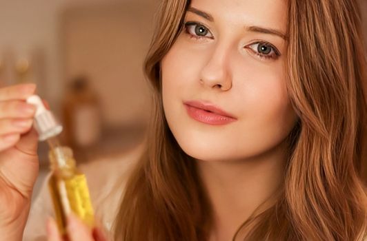 Beautiful woman with organic oil serum bottle, evening beauty and skincare routine.