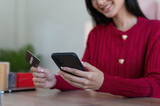 Young person using credit card and laptop computer. Online shopping, e-commerce concept.