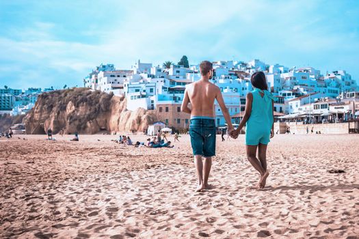 happy Young couple walking at the beach of Albufeira Algarve Portugal Algarve during summer