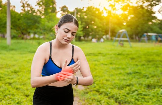 Fitness woman with wrist pain. Sport muscle injury concept. Runner girl with wrist pain outdoors. Concept of wrist pain and arthritis in the hands. Sport woman with arthritis in the wrist