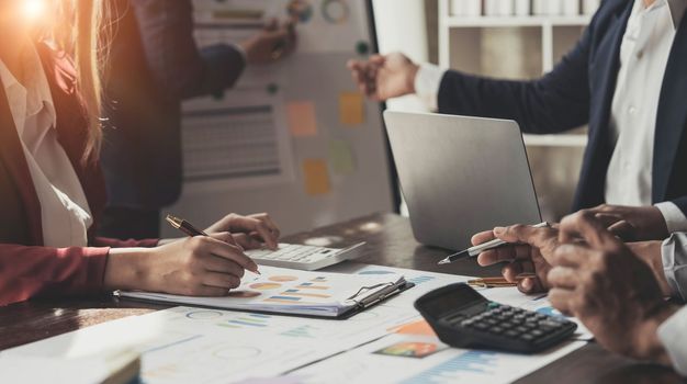 Business People Meeting using laptop computer,calculator,notebook,stock market chart paper for analysis Plans to improve quality next month. Conference Discussion Corporate Concept