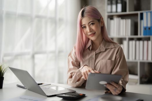 Asian Business woman working to analyze technical price graph and indicator with business team talking by cell phone. account or saving money or insurance concept.