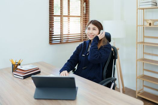 Portrait of a woman business owner showing a happy smiling face as he has successfully invested her business using computers and financial budget documents at work.