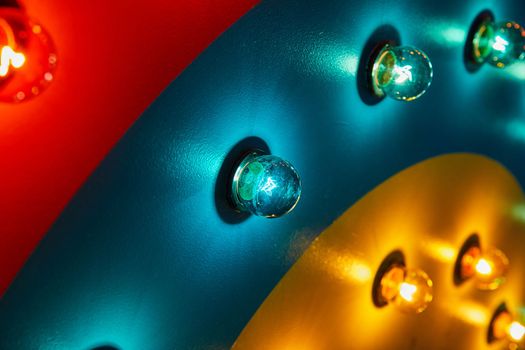 Image of Red, teal, and yellow wall with light bulbs covering