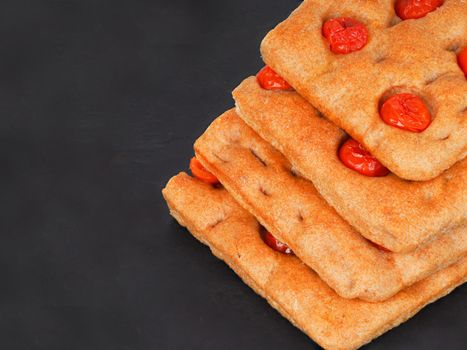 Italian flat bread organic wholewheat focaccia with tomatoes isolated in studio over a background
