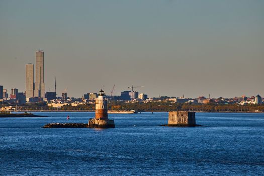 Image of Robbins Reef Lighthouse in New York City with Golden light and industrial city behind